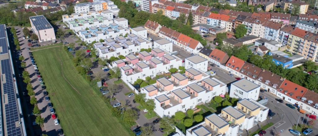 Luftbild Am Krenzelsberg 6 Wohnhöfe mit dreigeschossigen Häusern mit Flachdach. Helle Fassaden mit Farbakzenten. Die Höfe sind begrünt.