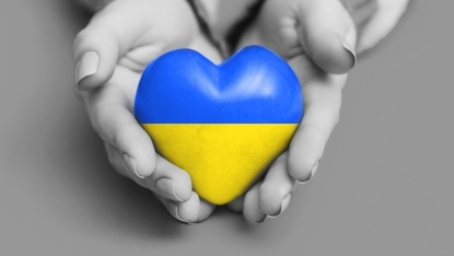 Hände halten Herz in Ukrainischen Landesfarben blau und gelb