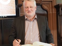 700 Jahre Freiheit: Ulrich Commerçon, SPD-Fraktionsvorsitzender im saarländischen Landtag, trägt sich ins Goldene Buch der Landeshauptstadt ein.