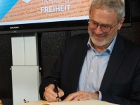 700 Jahre Freiheit: Hermann Josef Schmidt, Präsident Saarländischer Städte – und Gemeindetag u. Bürgermeister von Tholey, trägt sich ins Goldene Buch der Landeshauptstadt ein. 