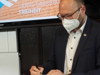 700 Jahre Freiheit: Mirko Bertucci, Fraktionsvors. SPD-Fraktion im Stadtrat,  trägt sich ins Goldene Buch der Landeshauptstadt ein.  