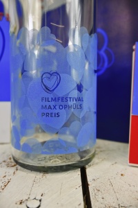 Ausschnitt Glasflasche mit blauen Herzen und Logo