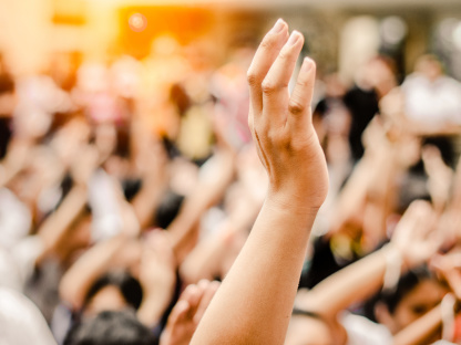 Symbolbild Bürgerbeteiligung mit erhobener Hand in der Menge