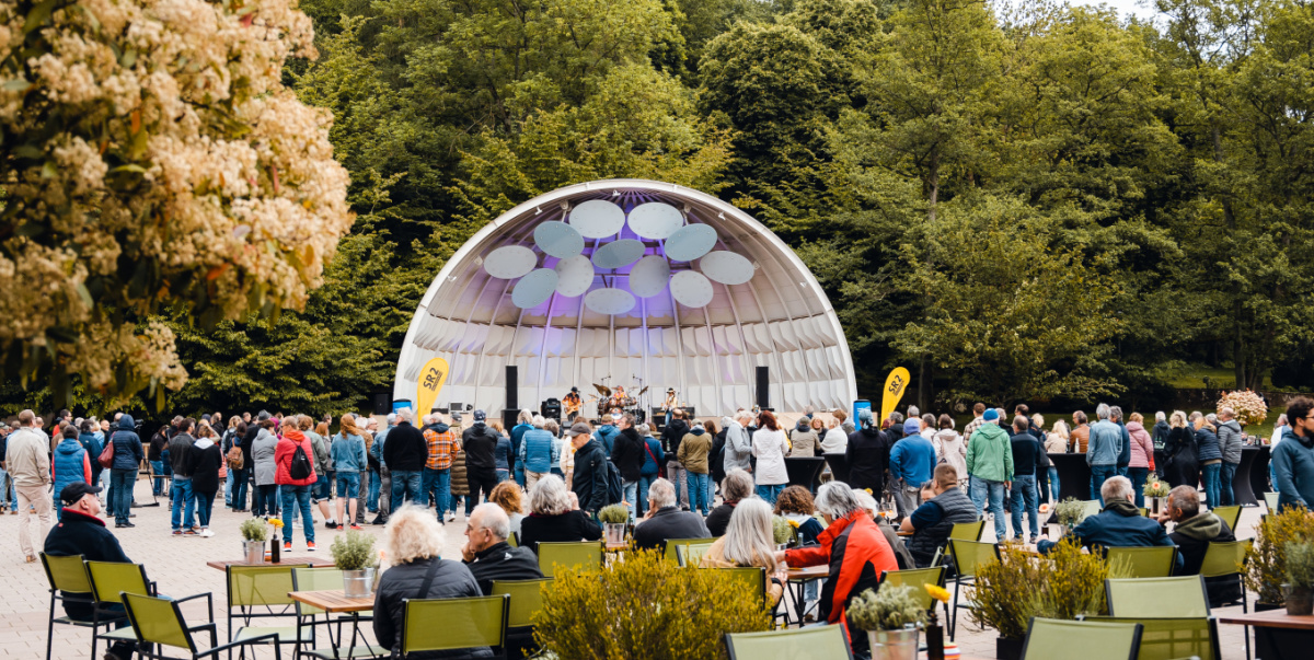 Zuschauende vor der Muschel mit Band im Deutsch-Französischer Garten