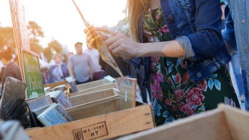 Menschen auf einem Markt, die durch Kisten mit Waren stöbern.