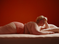 Frau liegt in Unterwäsche auf einem Bett