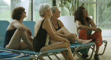 Vier Frauen auf Liegen im Schwimmbad