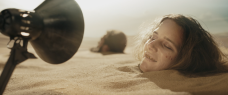 Frau in der Wüste im Sand vergraben wird von einer Lampe angeleuchtet