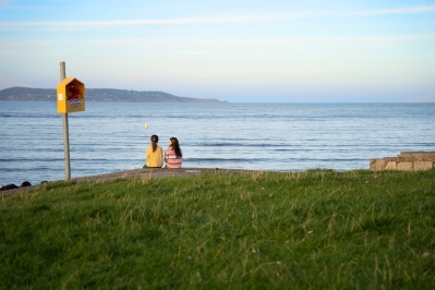 2 Mädchen sitzen am Ufer