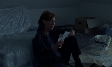 Frau sitzt auf dem Boden in einem Zimmer mit Kartons