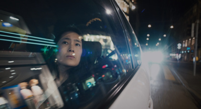 Eine Frau schaut aus dem Fenster eines fahrenden Autos in einer Stadt