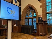 OB Uwe Conradt am Rednerpult im Rathausfestsaal, im Hintergrund eine Präsentation zum Jubiläum der Gebietsreform.