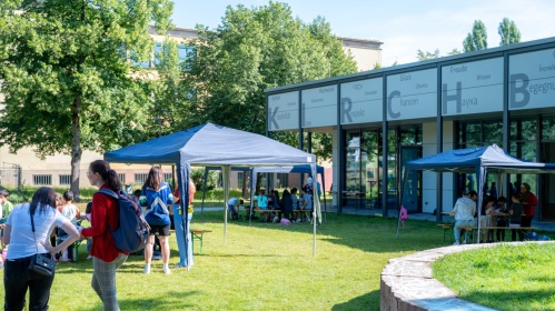Pavillons und Menschen beim Sprachcamp auf Rasen der Bildungswerkstatt