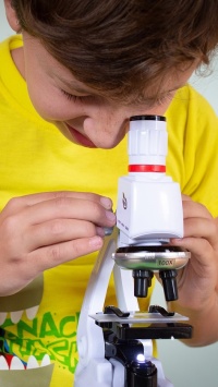 Ein Kind mit einem Mikroskop