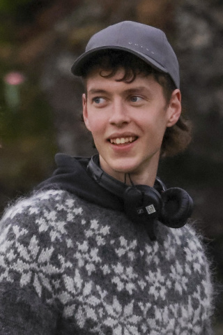 Junger Mann mit kurzen braunen Haaren, der eine Baseballcap trägt.