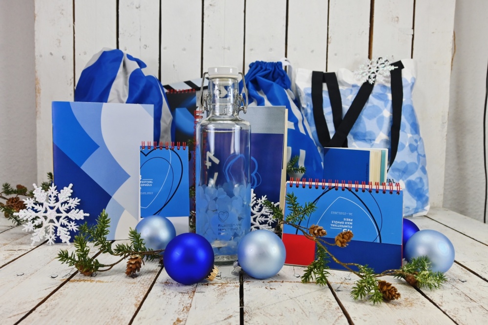 Geschenketaschen im Hintergrund, davor Max Ophüls Trinkflasche und Weihnachtsdekoration