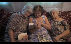 Drei Omas sitzen auf dem Sofa und schauen sich alte Fotos an Drei Omas sitzen auf dem Sofa und schauen sich alte Fotos an