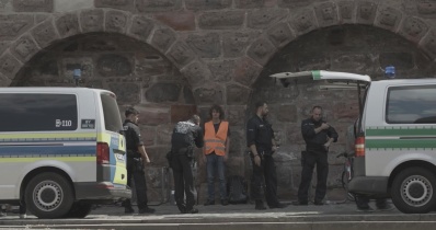 Polizeikontrolle einer Person in Warnweste.