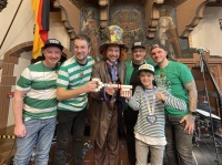 Fünf grün gekleidete Musiker der Band "Green Fiess" und ein verkleideter Oberbürgermeister Uwe Conradt am Fetten Donnerstag 2025 im Rathaus St. Johann