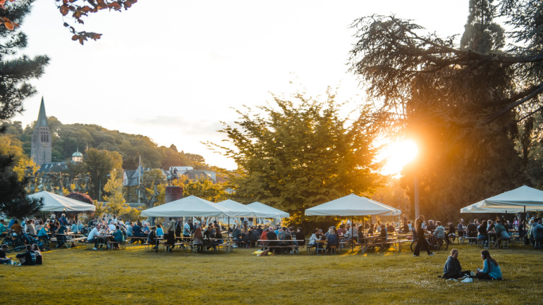 Personen Sitzen am Saarbrücker Staden und die Sonne scheint im Hintergrund