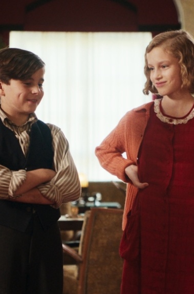 Das geheime Stockwerk Zwei Jungen und ein Mädchen stehen zusammen in einer Hotellobby.