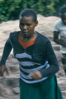 Girls don't cry Zwei junge Mädchen rennen über unebenes, steiniges Gelände im Freien.