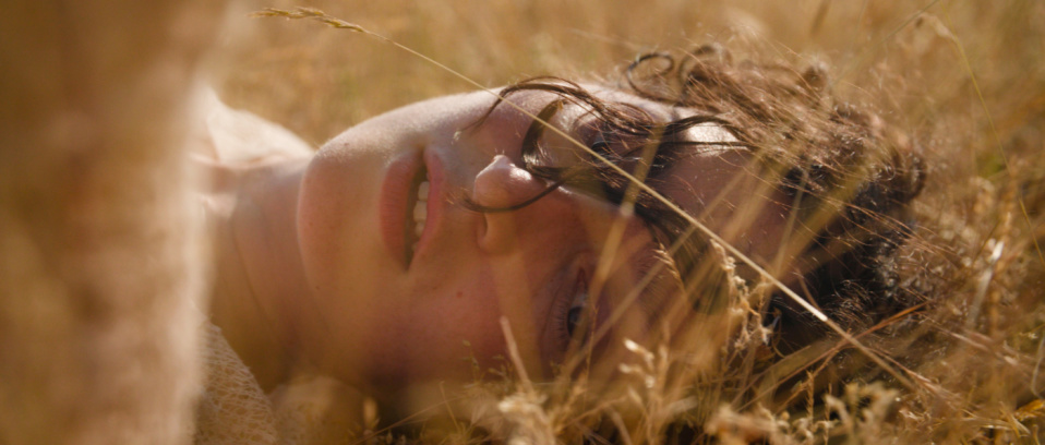 Eine braunhaarige Frau liegt in einem Feld. Eine braunhaarige Frau liegt in einem Feld.