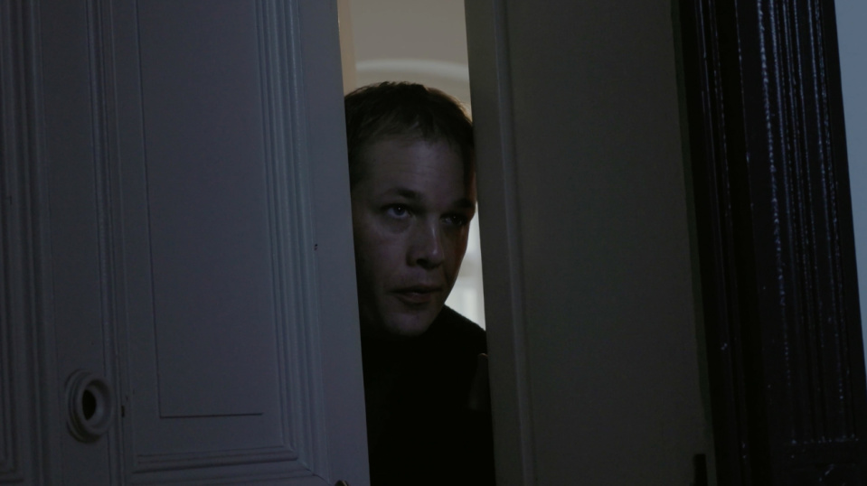 Ein Mann schaut durch einen Türspalt. Ein Mann schaut durch einen Türspalt.