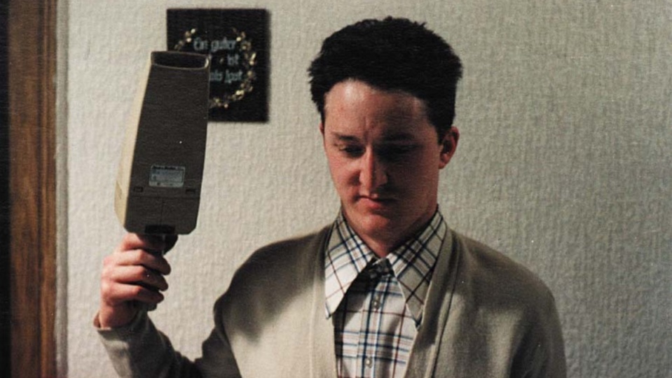 Einer junger Mann schaut vor sich und hält in seiner rechten Hand einen Handstaubsauger. Einer junger Mann schaut vor sich und hält in seiner rechten Hand einen Handstaubsauger.