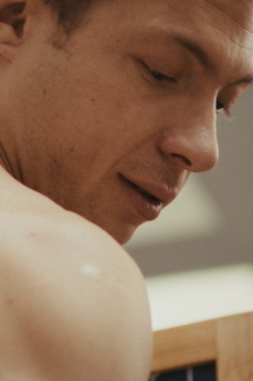 Ein Mann blickt seitwärts über seine Schulter.