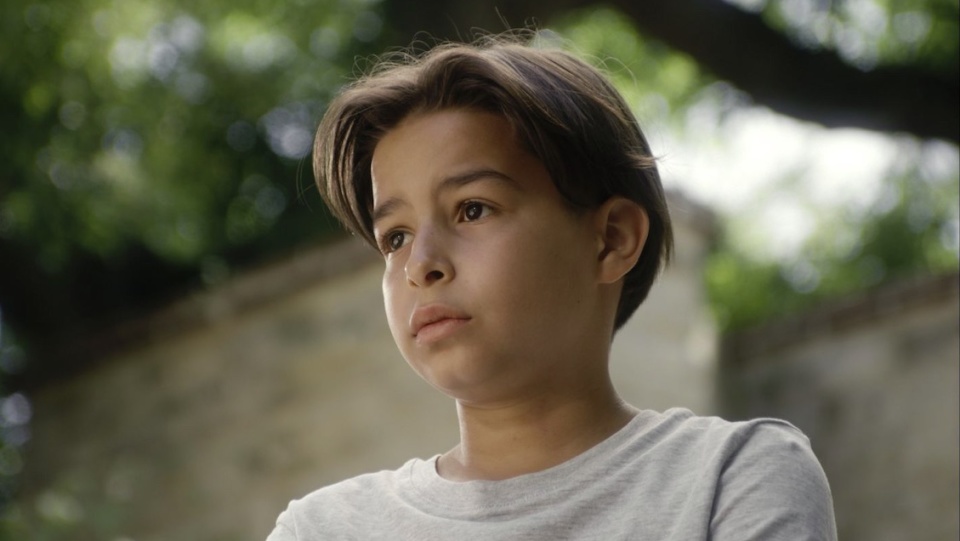 Ein kleiner Junge steht draußen vor einer Mauer. Ein kleiner Junge steht draußen vor einer Mauer.