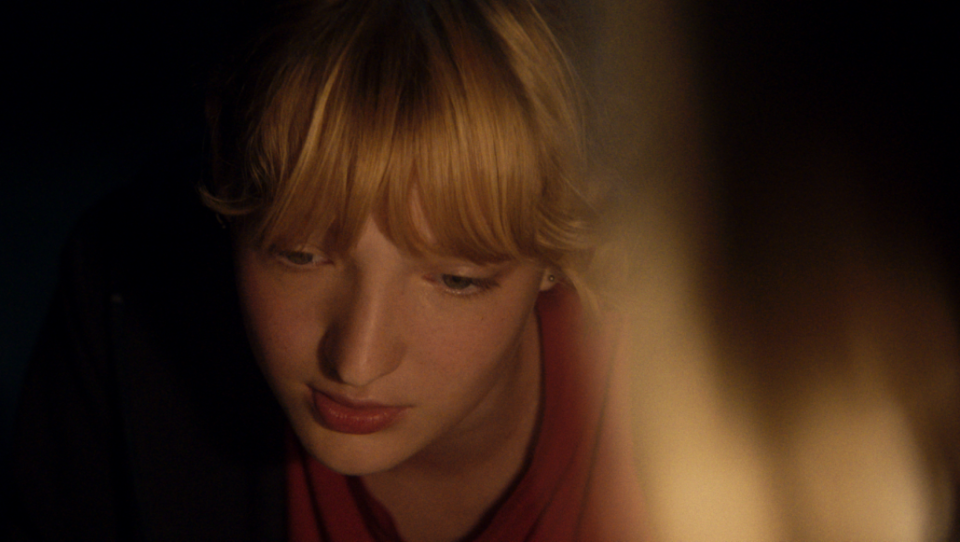 Eine blonde Frau befindet sich in einem dunklen Raum. Eine blonde Frau befindet sich in einem dunklen Raum.