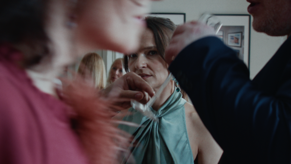 Eine Frau steht inmitten eines Raums, um sie herum Menschen. Eine Frau steht inmitten eines Raums, um sie herum Menschen.