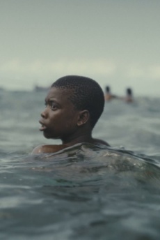 Ein Junge schwimmt im Meer. Im Hintergrund ist ein Boot zu sehen.