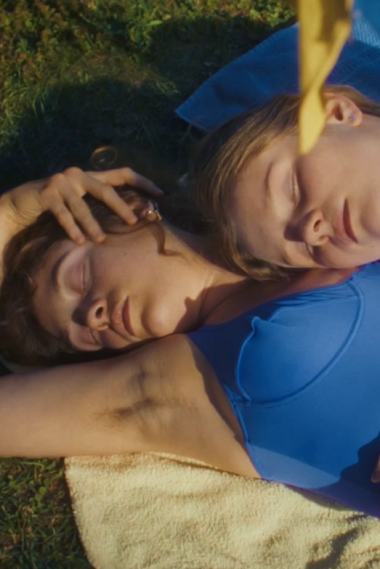 BLEISTIFTSTRICHE Zwei Frauen liegen in Badeanzug auf einer Decke.