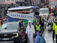 in Umzugswagen mit der Aufschrift „SAARRAKETEN“ fährt durch eine volle Straße, begleitet von vielen Menschen und Zuschauern entlang der Strecke.