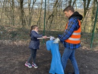 Auftakt zur Picobelloaktion 2026 an der Grundschule Gersweiler Mädchen sammelt Müll mit Greifzange, ein Erwachsener hält einen Müllsack