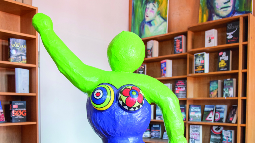 Kultur- und Lesetreff Brebach Eine Kunstfigur vor Bücherregalen