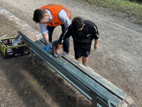 Oberbürgermeister Uwe Conradt streicht gemeinsam mit einem Jungen eine Holzbank auf einem Spielplatz.