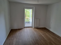 Zimmer mit Balkontür,  Wände und Decken weiß, Vinylboden eichefarben